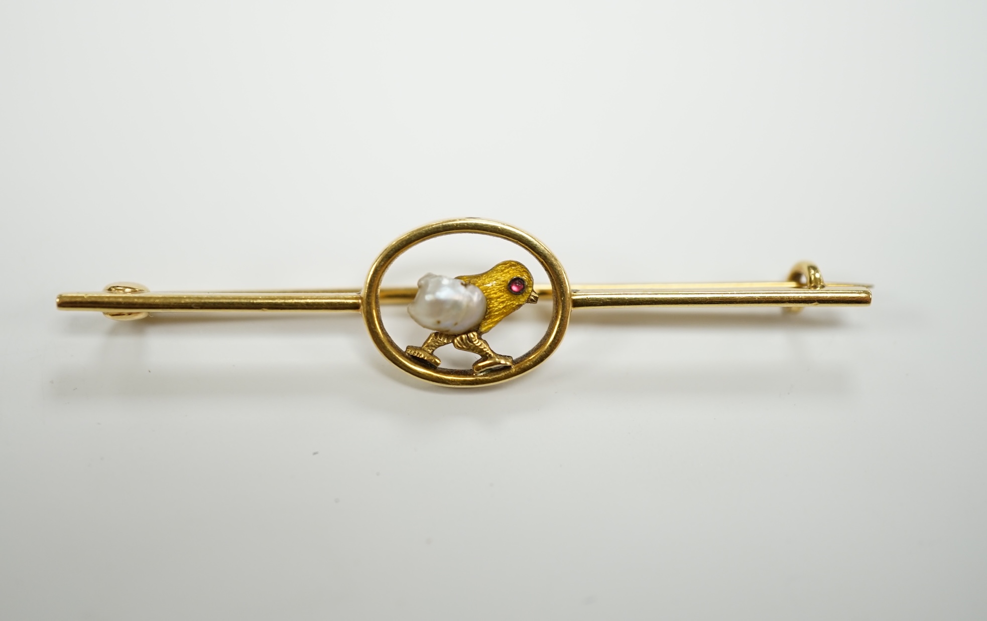 An early 20th century yellow metal, enamel and single stone baroque pearl set bar brooch, modelled as a hatching chick, 50mm, gross weight 3.8 grams.